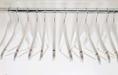 Wooden white clothes hangers inside the closet