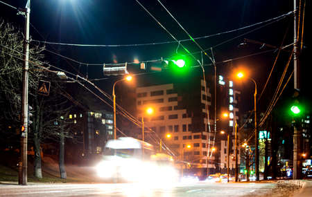 Blurred light from the headlights of cars moving on the asphalt road in the city at nightの写真素材