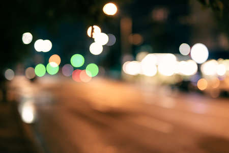 Blurred background of city street with cars and different lighting at nightの写真素材