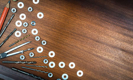 Knolling style photo - various items and tools for home repair on a background of brown wood texture