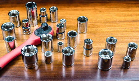 Set of hexagonal metal chrome heads for ratchet key on brown wood texture backgroundの写真素材