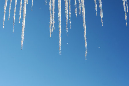 Icicles against blue skyの写真素材