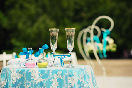 Two champagne glasses and two bottles with colored sand. Wedding ceremony.の写真素材