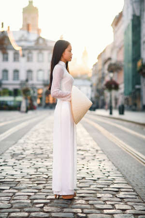 Beautiful happy asian girl dressed in national traditional Ao Dai dress with vietnamese conical hat Non La, Leaf Hat.の写真素材