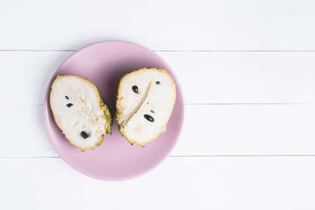 Fresh exotic tropical fruit. Two halfs of custard apple isolated on white background, annona cherimoya.の写真素材