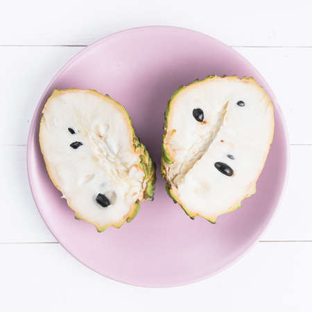 Fresh exotic tropical fruit. Two halfs of custard apple isolated on white background, annona cherimoya.の写真素材