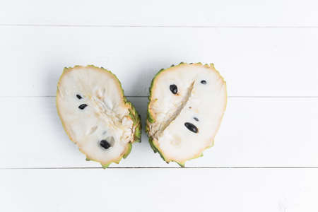 Fresh exotic tropical fruit. Two halfs of custard apple isolated on white background, annona cherimoya.の写真素材
