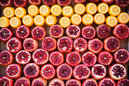 A variety of ripe juicy fruits on the market, peeled pomegranate, chopped orange.の写真素材