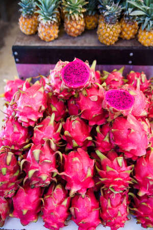 A lot of red ripe pitaya or white pitahaya dragon fruit on outdoor market.の写真素材