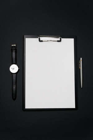 Clean white sheet of paper with free copy space, laptop, watch and pen on black backgroun.の写真素材
