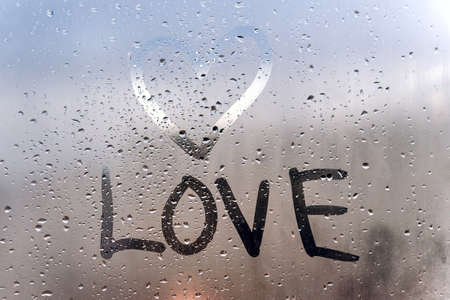 the inscription love and hand-drawn heart on the sweaty glass.の写真素材