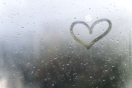 Rainy weather, the inscription heart on the sweaty glassの写真素材