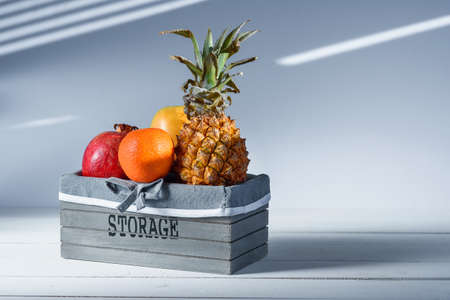 Fresh fruits in grey wooden box with inscription Storage.の写真素材
