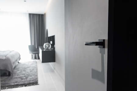 Modern black door handle and lock on black wooden hidden door. Close-up elements of the modern...