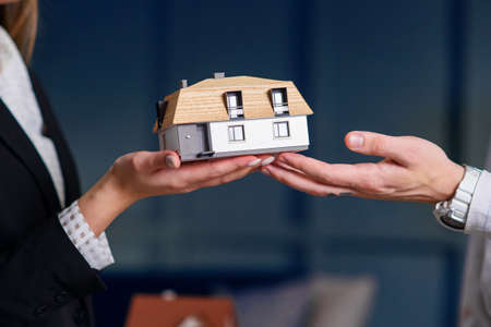 Man and woman hands holding 3d model of house.の写真素材