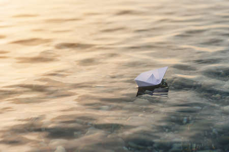 Origami white paper boat on blue deep water.の写真素材