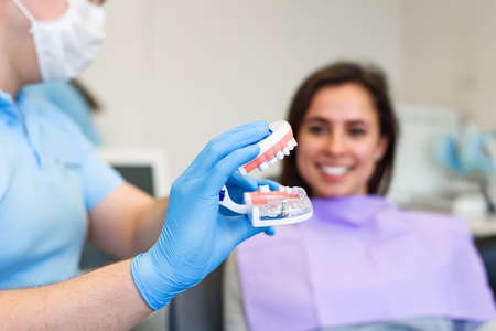 The dentist speaks with the female patient in modern clinic.