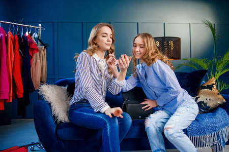 Stylish two young woman during shooting beauty video blog in the office.の写真素材