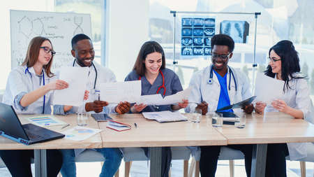 Team of multiethnic doctors having a meeting in conference room in the modern hospital. Group of multiethnic doctors are medical studying studying disease histories patients,の写真素材