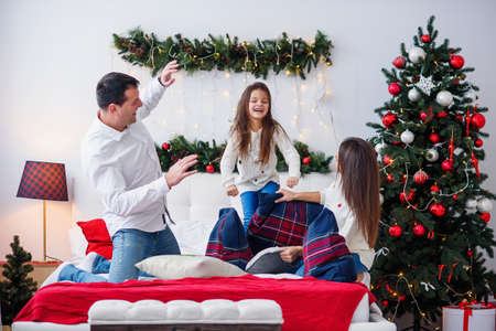 Portrait of happy parents and their daughter having fun at homeの写真素材