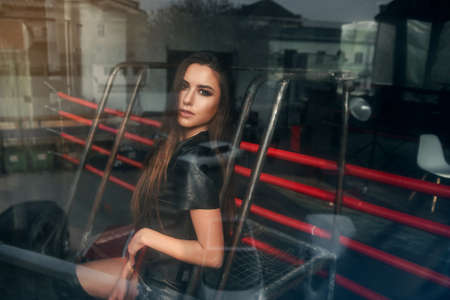 Attractive model wearing leather shorts and jacket posing on boxing ring.の写真素材