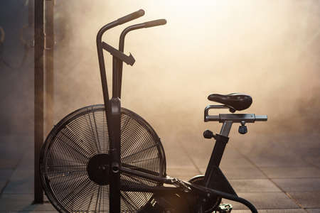 The exercise bike at the modern gym full of smoke and sunlight.