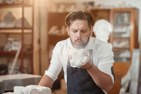 Craftsman hands working with stone sculptor at creative workplace in the atmospheric studio.の写真素材