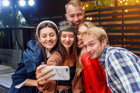 Happy four friends watching internet social media in cell phone. Every one with his own phone