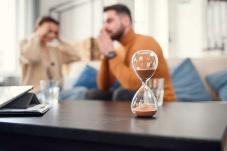 Couple sitting with psychologist during the mental therapy, cropped image with no face