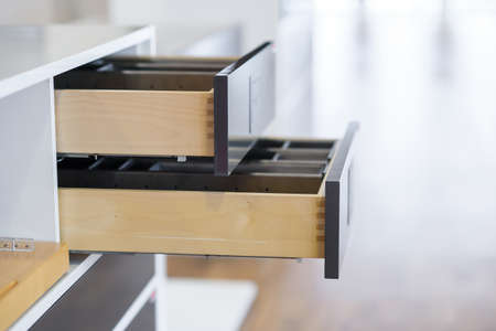 Opened kitchen drawer with cutlery tray. Two drawers are hide behind the high front. Smart storage...