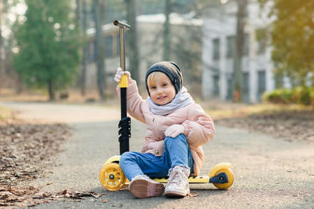 cute little toddler girl riding scooter in the city, kids sportの写真素材