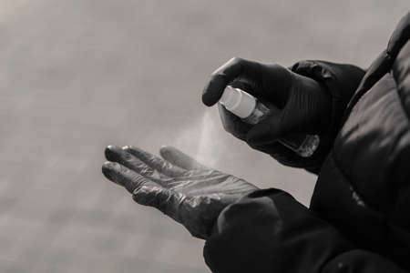 Coronavirus world pandemic concept. Female hands spraying disinfection liquid for protection herself...