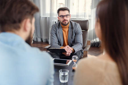 Qualified psychologist listen family problems of young unhappy couple.の写真素材