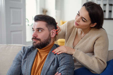 Attractive woman apologizing to frustrated man after quarrel, doubting boyfriend ignore, girlfriend feeling guilty, asking forgive her, begging pardon, admits mistake, regret, couple having problemの写真素材