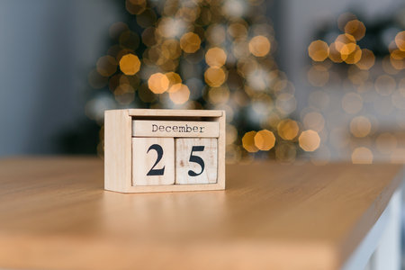 Wooden blocks calendar with the date of December 25 on the Christmas lights bokeh background.の写真素材