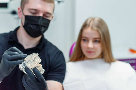 The dentist speaks with the female patient in modern clinic.の写真素材