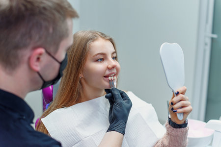 Dentist matching patients teeth color with palette in officeの写真素材