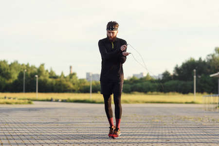 Fitness sports man jumping with skipping rope outdoors.の写真素材