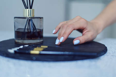 Beautiful female hands with a gentle blue manicure on a stand at beauty salon.の写真素材
