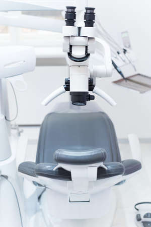 Dental binocular microscope on the background of modern dental clinic. Professional medical equipment.の写真素材