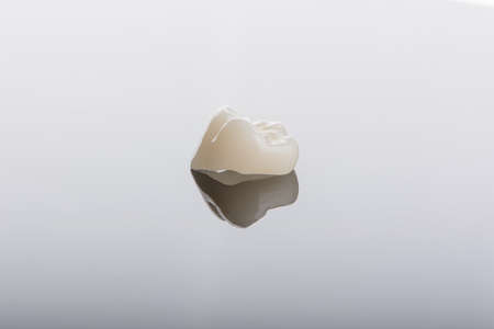 Qualified anatomic ceramic and zirconia crowns of human teeth close up macro isolated on black background.の写真素材