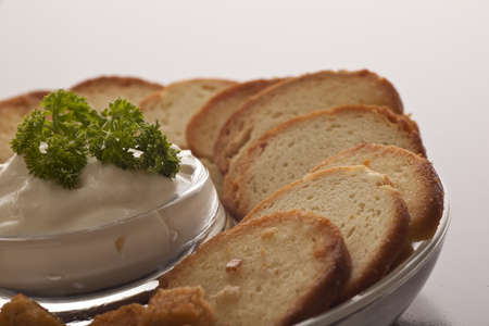 Delicious creamy savoury dip garnished with parsley and sliced rye bread served as an appetizer at a catered eventの写真素材