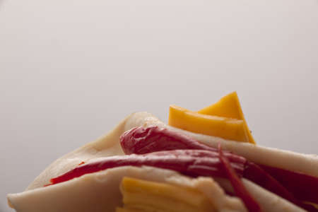 Closeup of a topping of cold smoked ham, salami and cheese against a neutral studio background with copyspaceの写真素材