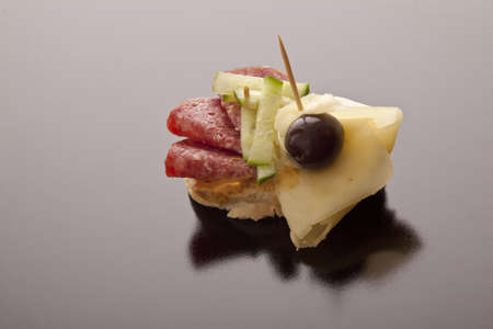 Salami, black olive and cheese on sliced baguette for tasty appetizers before a meal