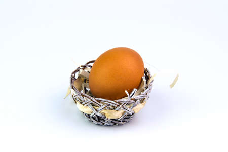 Chicken egg in a basket on a white background.
