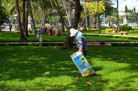 Vung Tau, Vietnam - January 26, 2018: The worker removes fallen leaves in the park