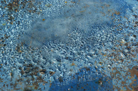 Water vapor under glass that lies on a rusty iron barrel, drops of water