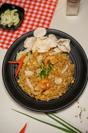 Fried rice with prawns and vegetables in a black plateの写真素材