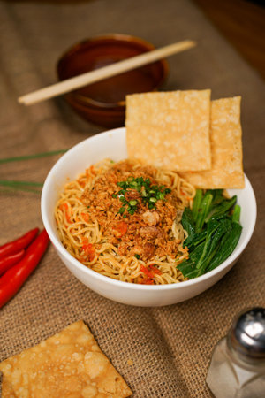 Instant noodles with minced meat and vegetables in a bowl with chopsticksの写真素材