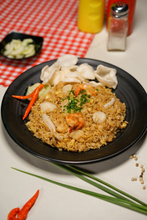 Fried rice with shrimps and vegetables in a black plateの写真素材